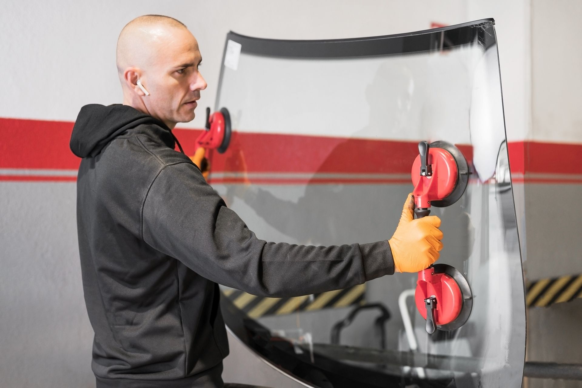 A man is installing a windshield on a car.