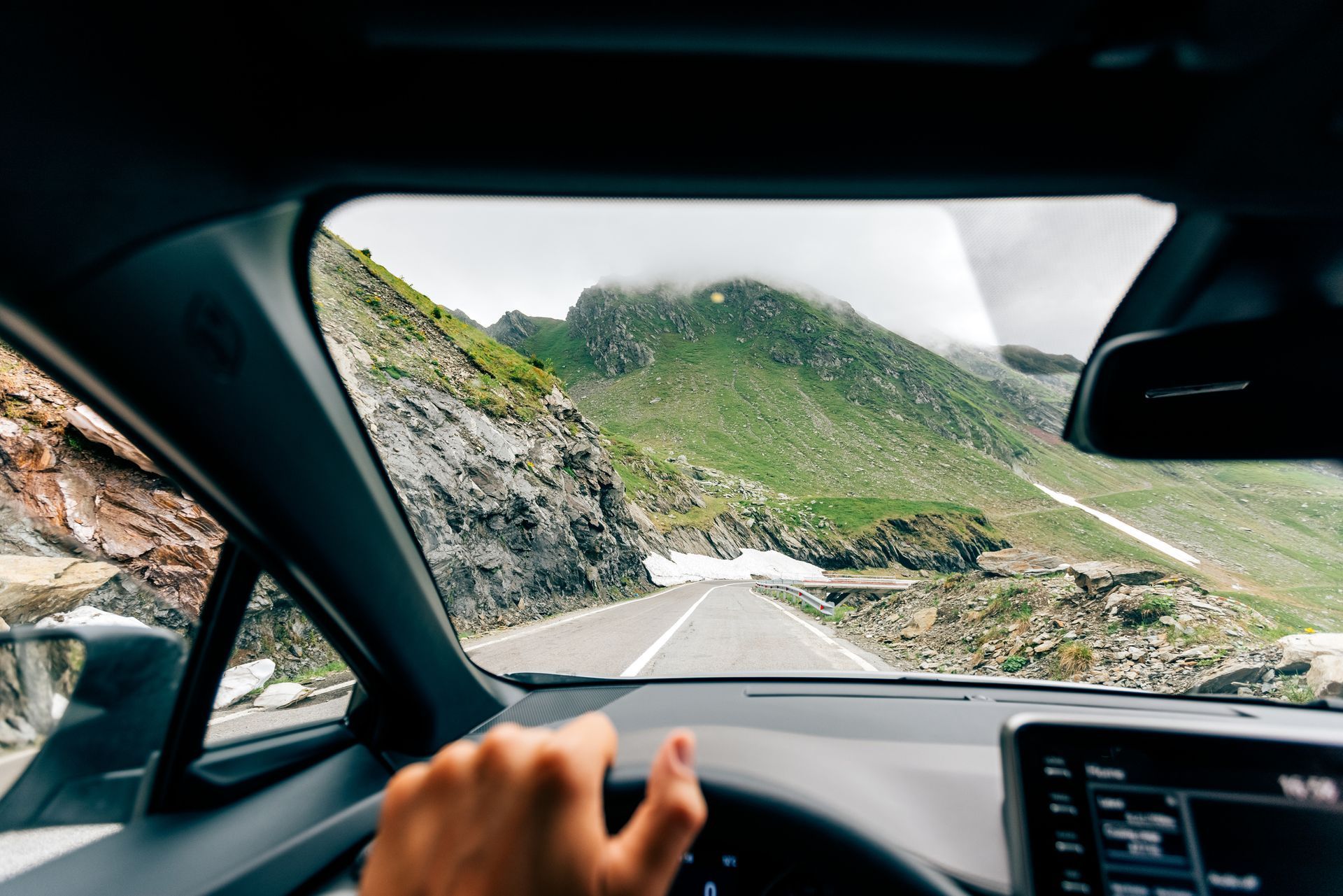 A person is driving a car down a mountain road.