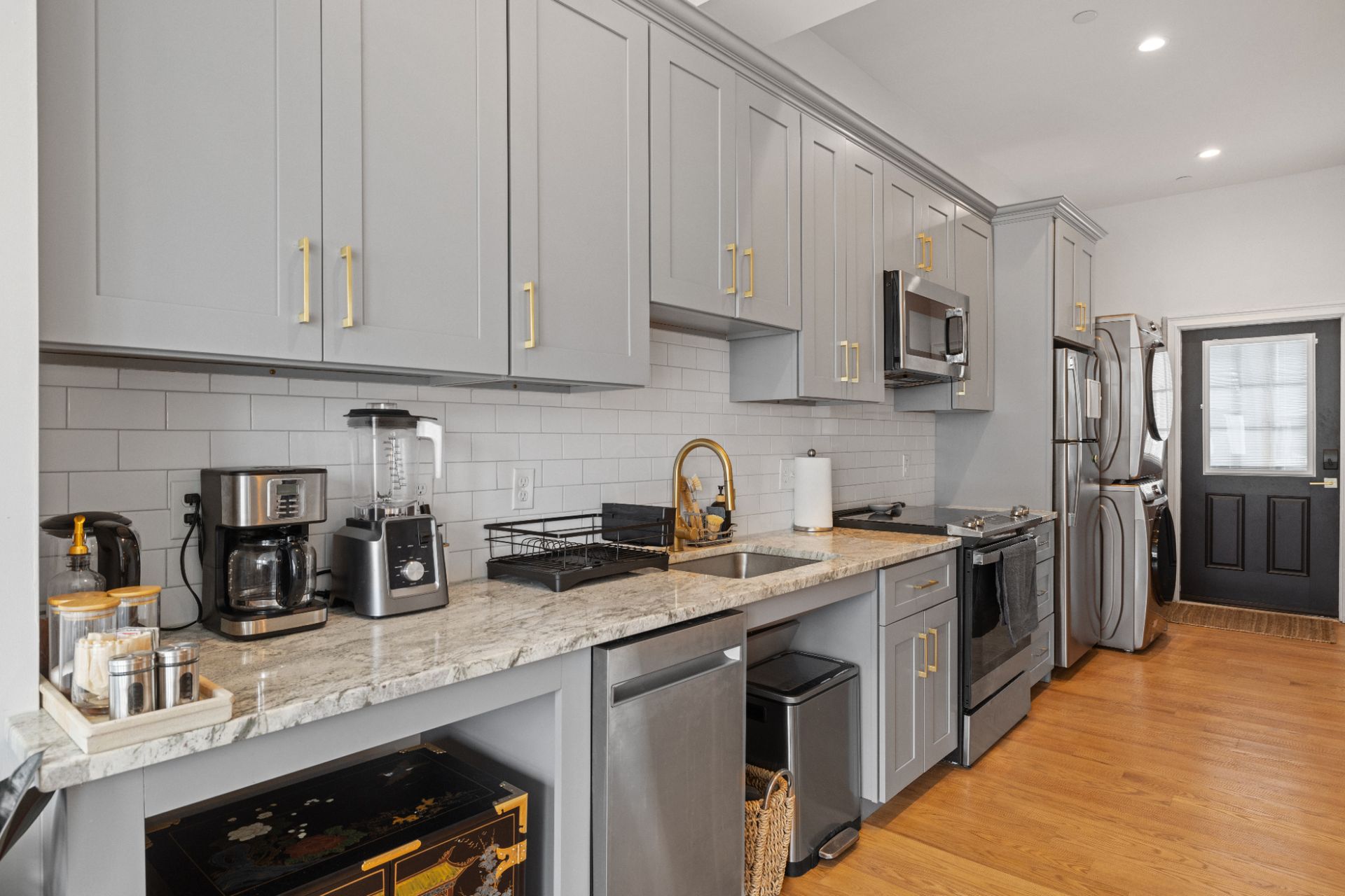 A kitchen with stainless steel appliances and gray cabinets.