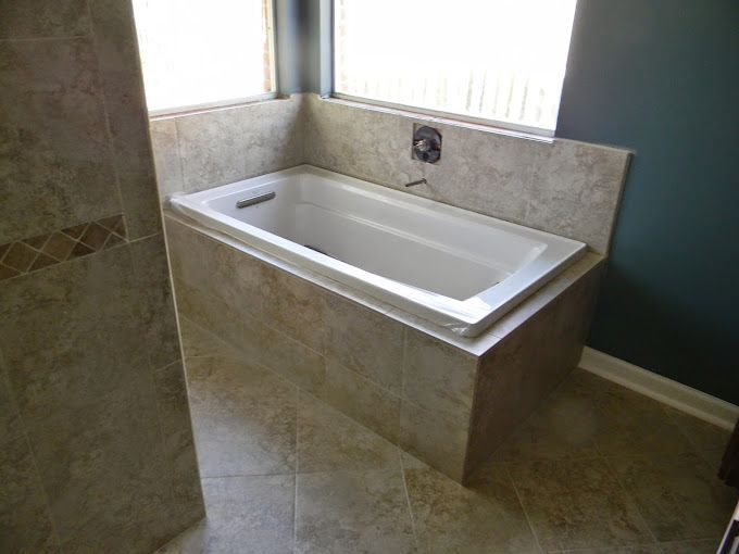 A bathtub is sitting in a bathroom next to a window.