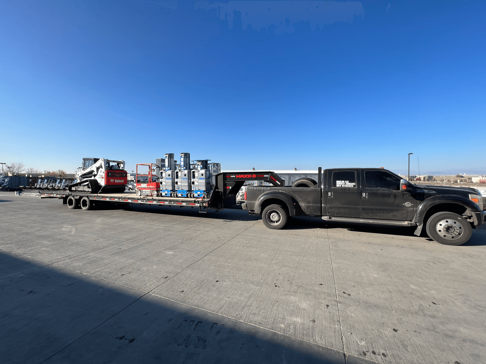 skidster and other equipment transported on flatbed trailer by haul3d