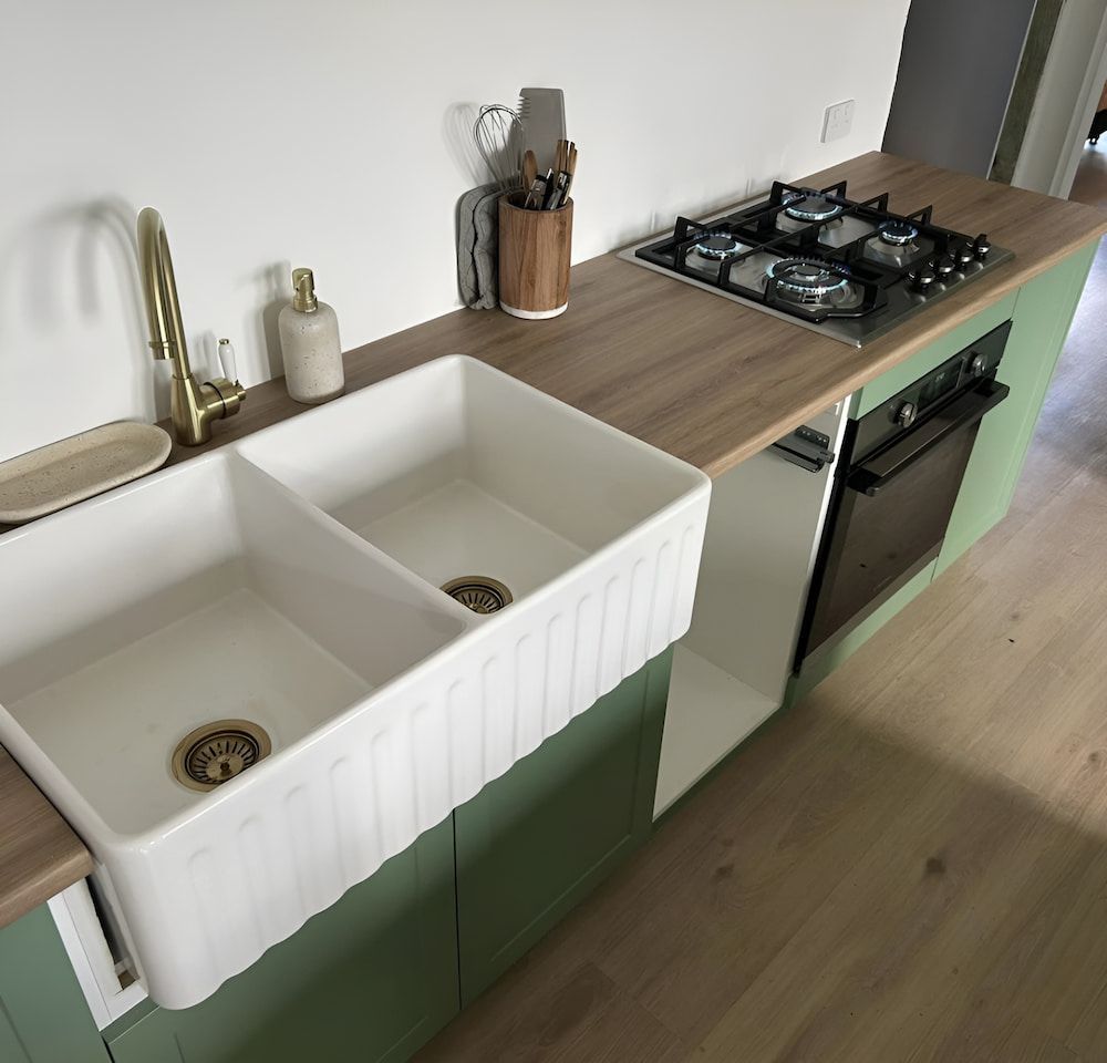 A Kitchen With Two Sinks And A Stove Top Oven — DMK Plumbing in Port Macquarie, NSW