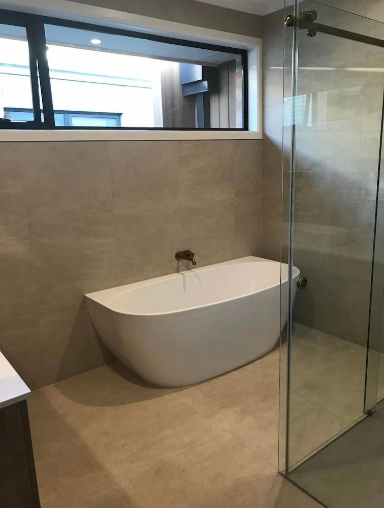 A Bathroom With A Bathtub And A Walk In Shower — DMK Plumbing in Crescent Head, NSW