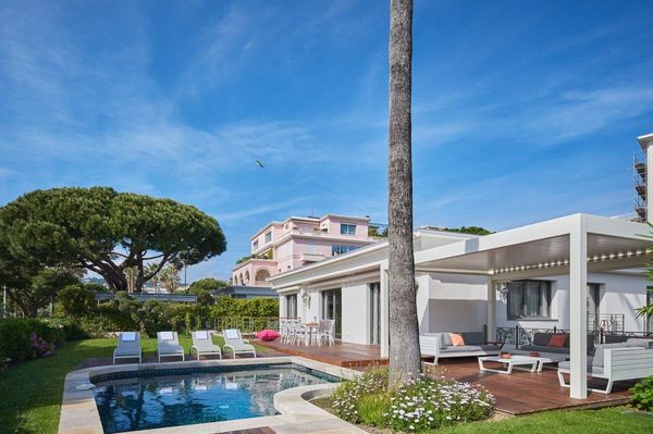 Villa Maria sur la Croisette, Cannes : jardin, piscine et terrasse en bois sous un ciel bleu