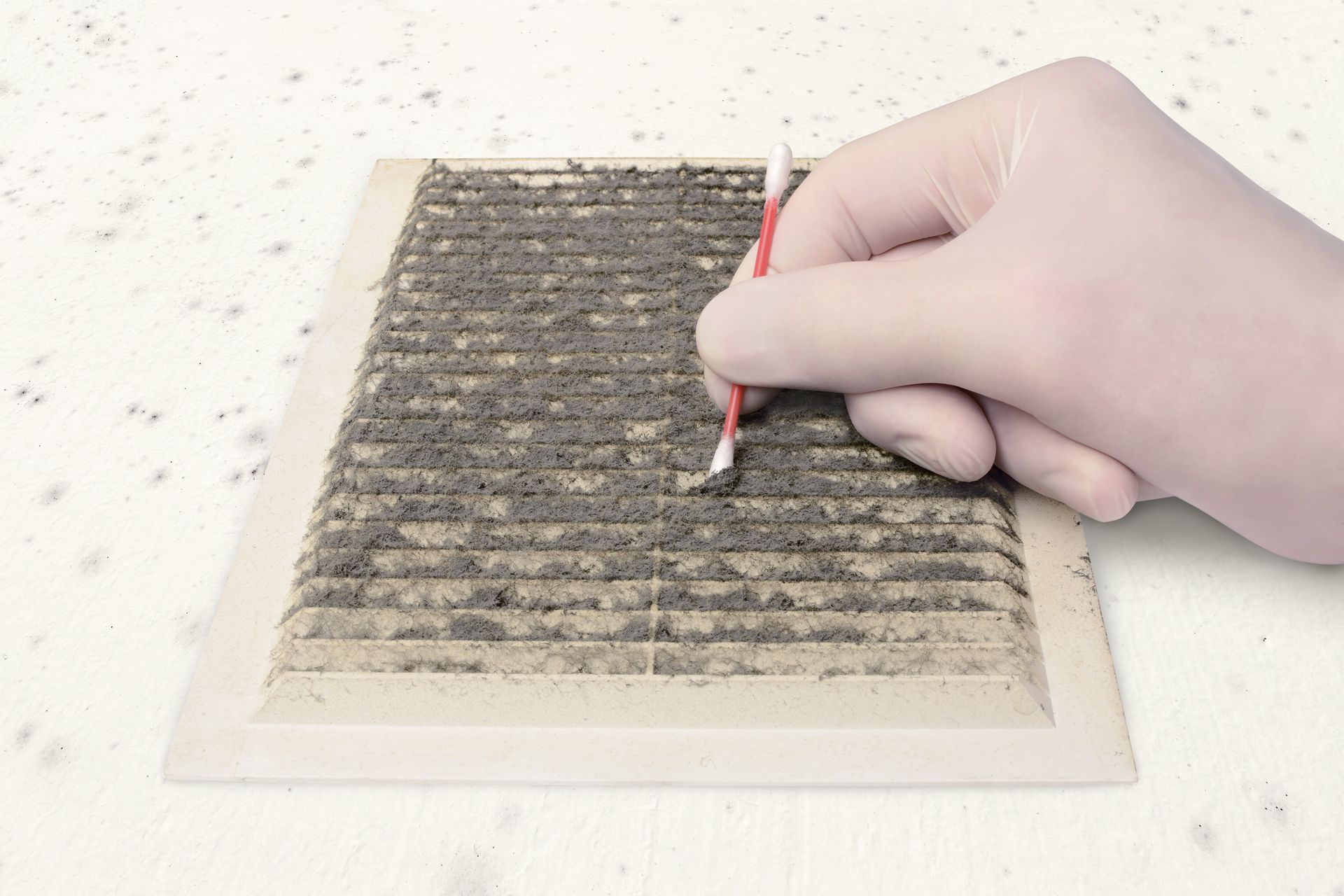 Hand drawing or scraping a dark textured pattern on a beige surface with a small tool