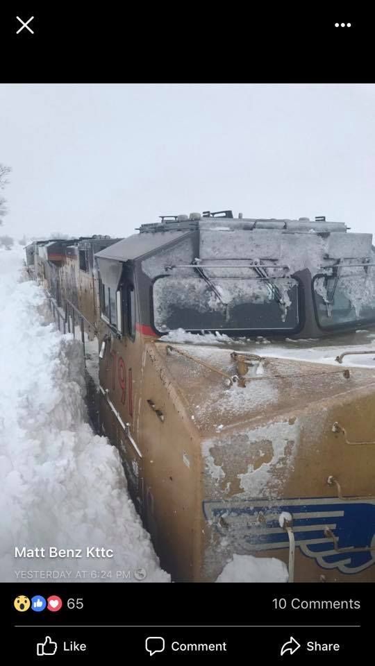 A train is sitting in the snow on the side of the road.