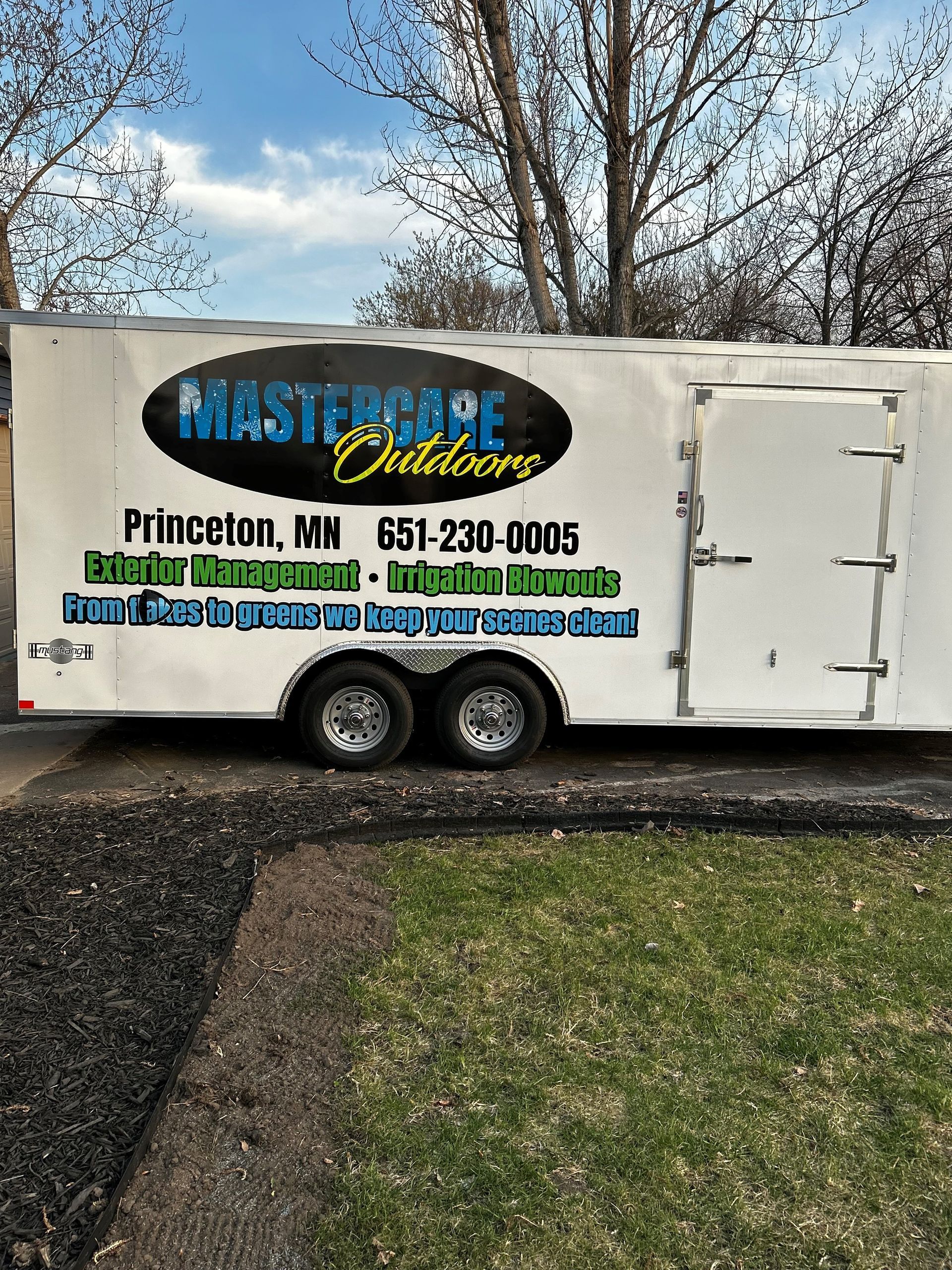 A white trailer is parked on the side of the road.