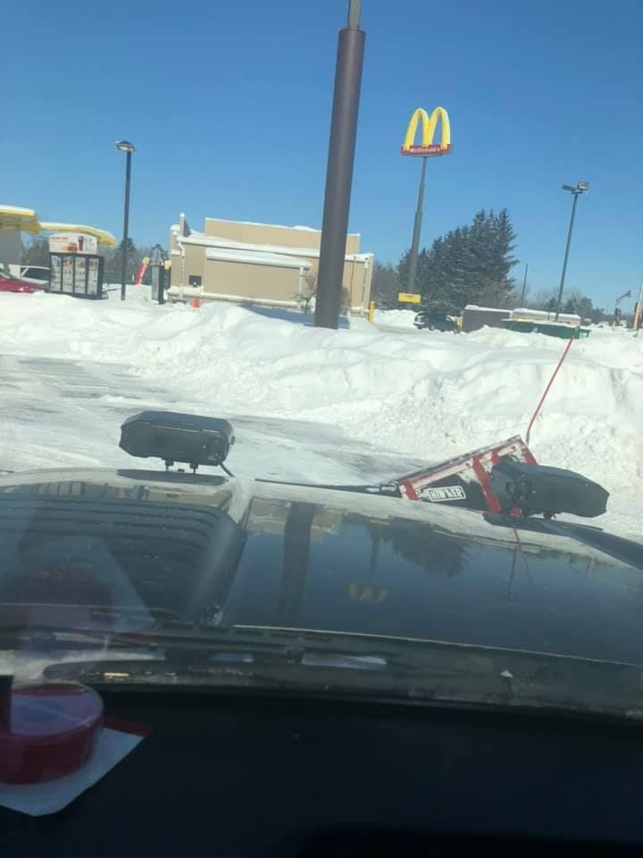 A mcdonald 's sign is visible through the windshield of a car