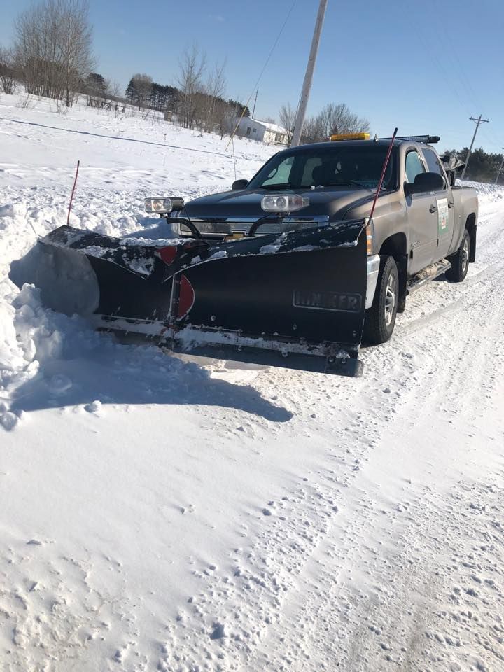 A truck is plowing snow on a snowy road.