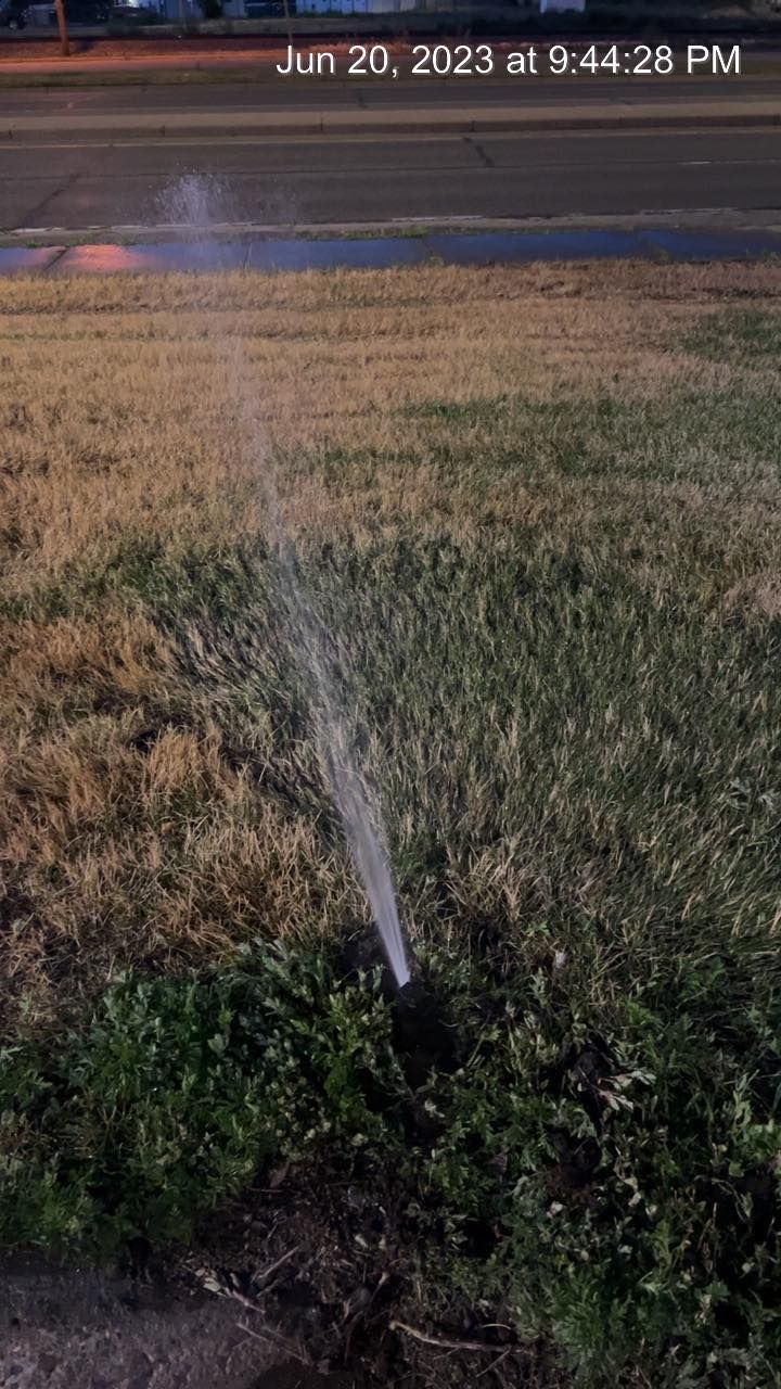 A sprinkler is spraying water on a grassy field.