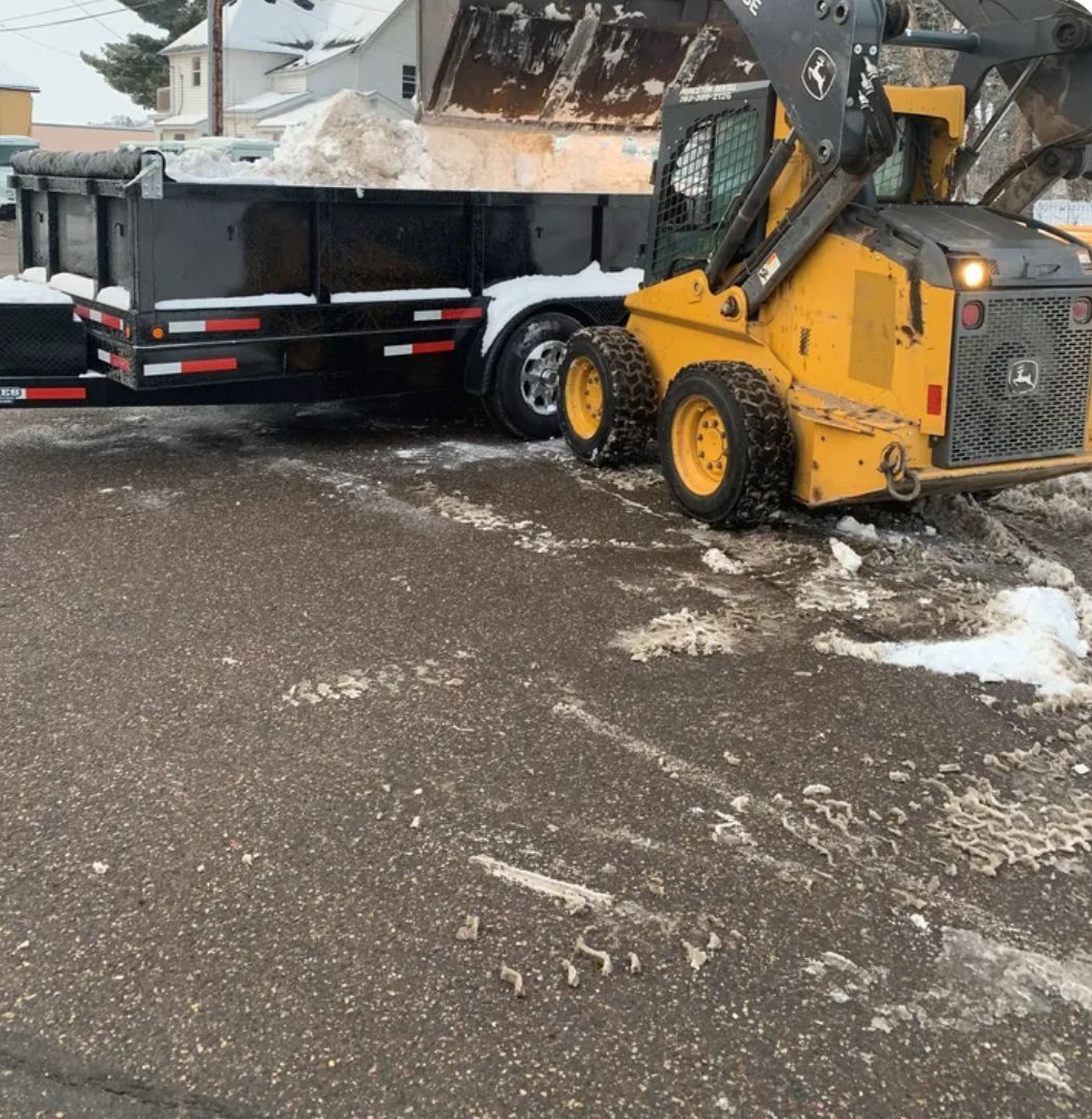 A dump truck with a trailer attached to it is parked on the side of the road.