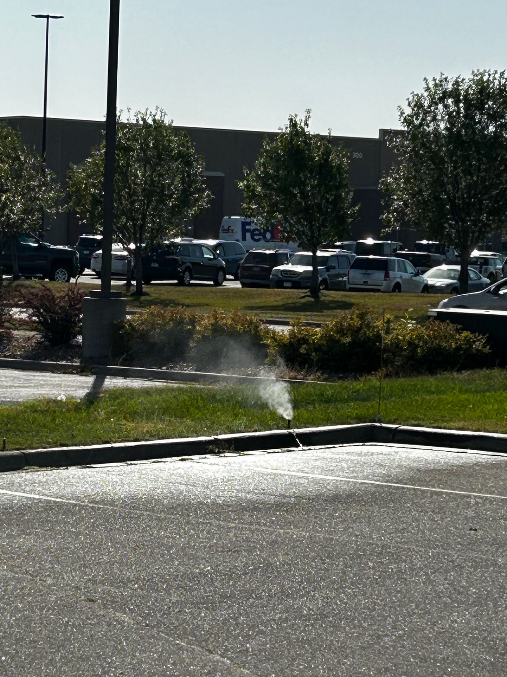 A parking lot with a fedex truck in the background