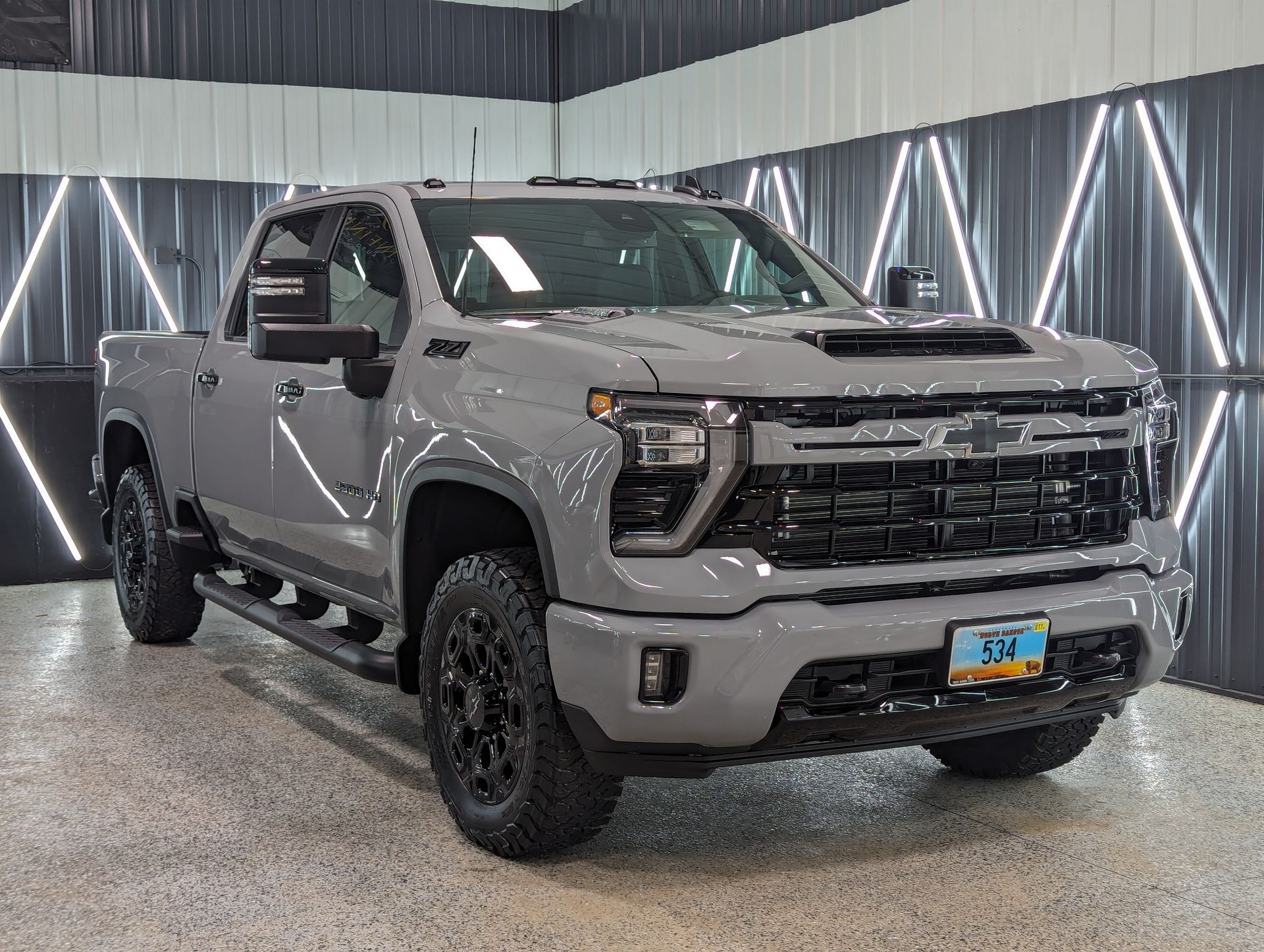 Gray Chevrolet Silverado pickup truck in a showroom.