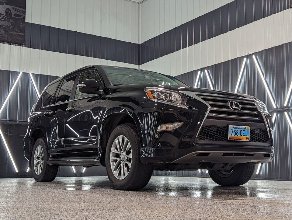 A black lexus gx is parked in a garage.