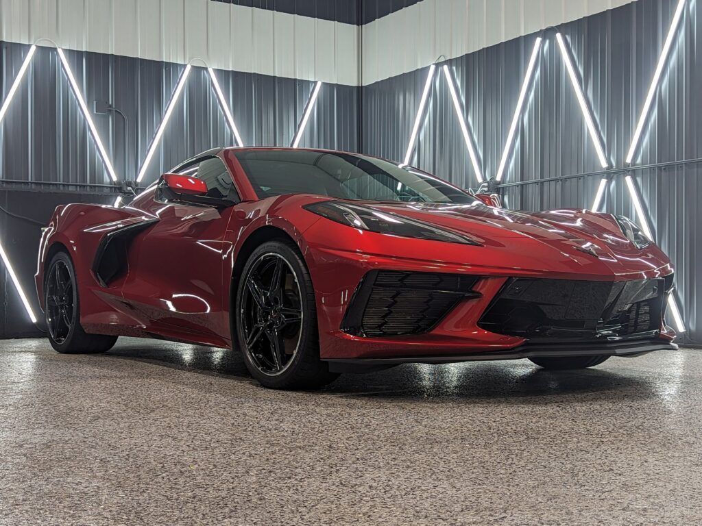 A red sports car is parked in a garage.