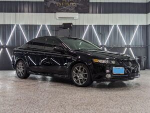 A black acura tl is parked in a garage.