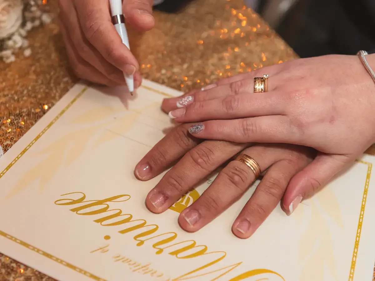 Hands with wedding rings signing a marriage certificate, Bodas by Lina, Santa Clara, CA.