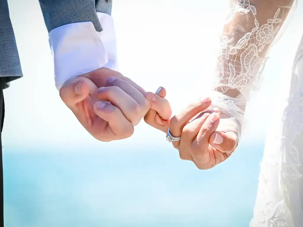 Couple holding hands, pinky fingers interlocked, with wedding ring visible. Bodas by Lina, Santa Clara, CA.