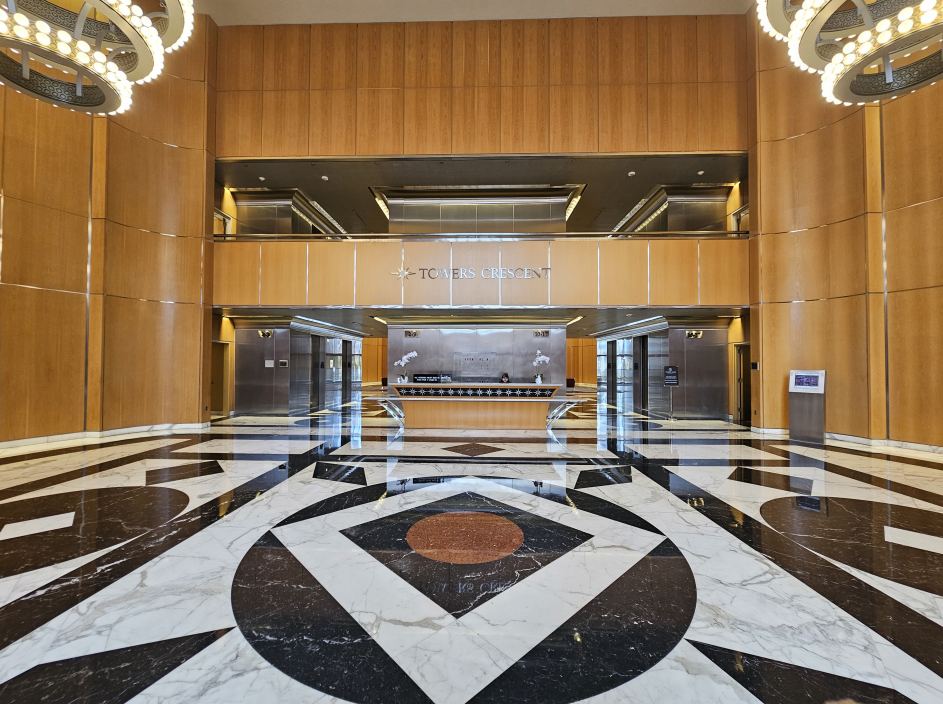 A large lobby with a marble floor and wooden walls