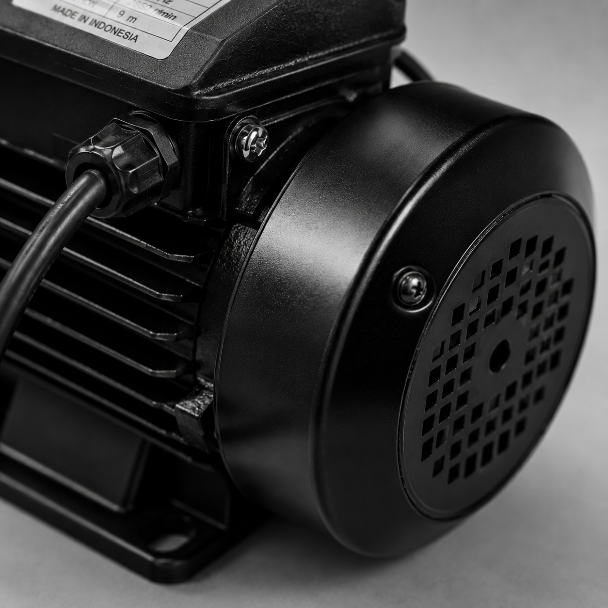 Black electric motor with vented end cap and attached cable, shown in close-up.