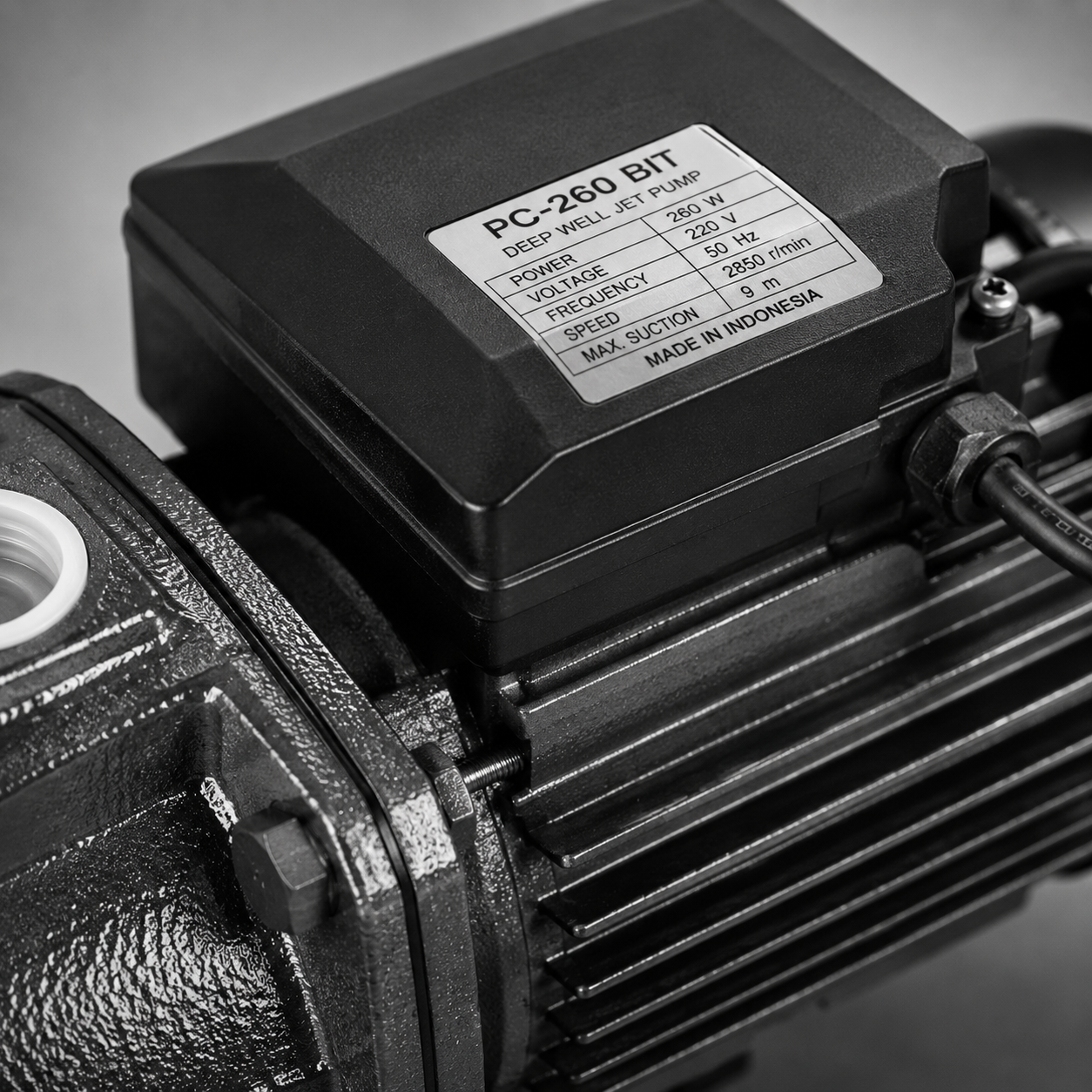 Close-up of a black electric motor with a white specification label on top