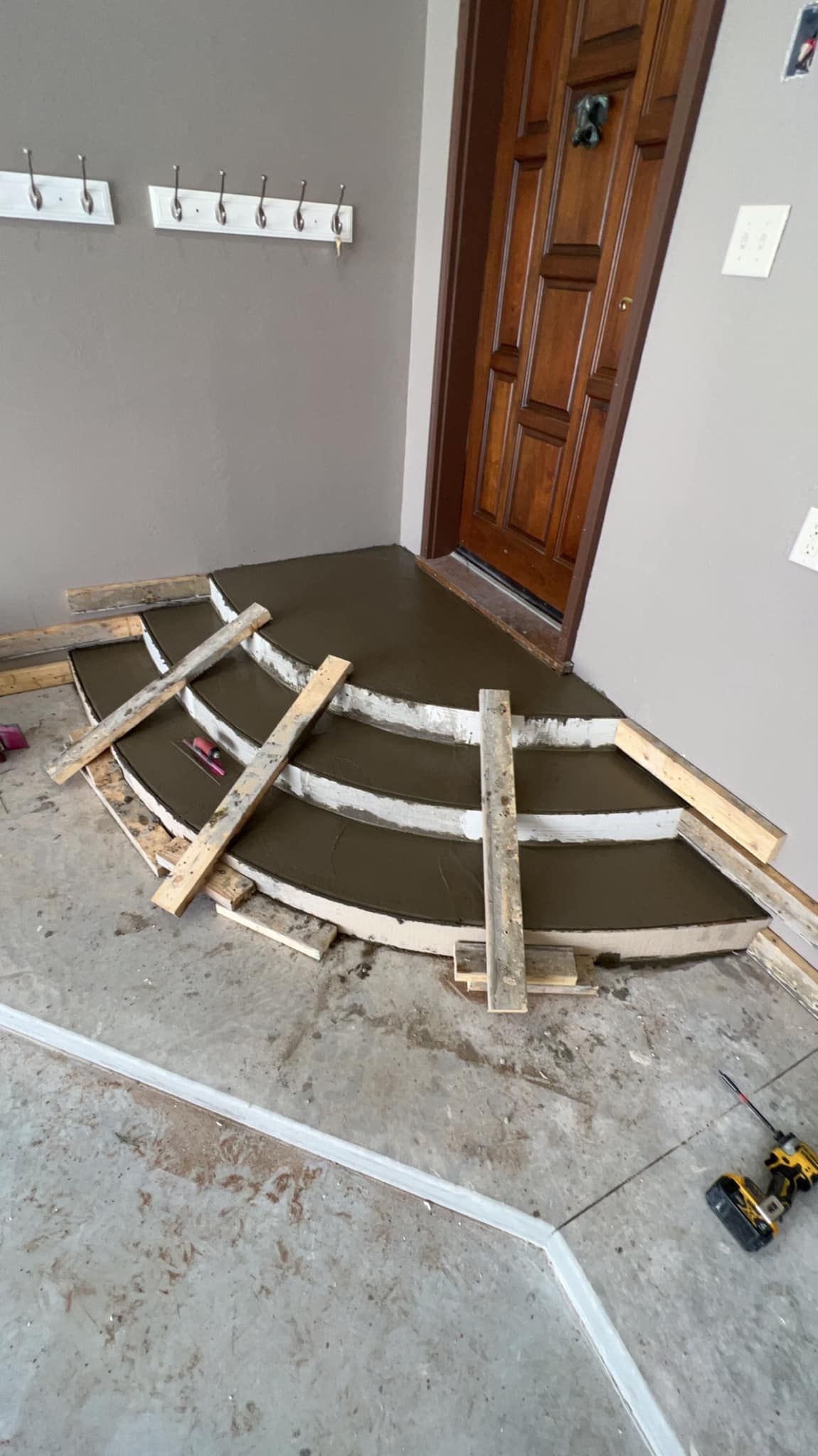 Concrete entryway under construction, wooden forms defining curved shape.