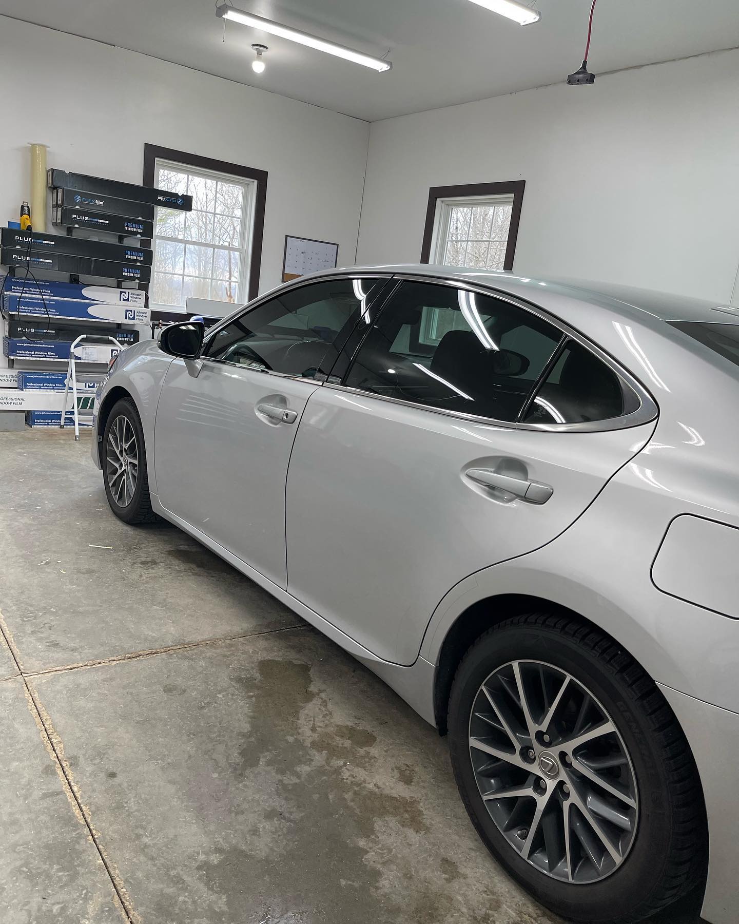 Silver sedan with tinted windows parked in a garage.