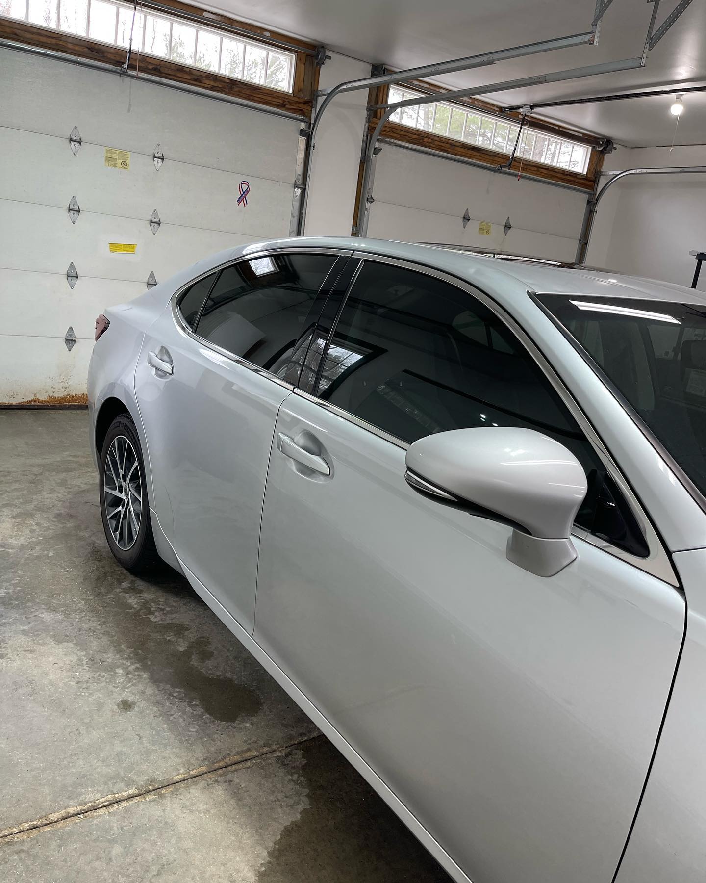 Silver car with tinted windows parked in a garage.