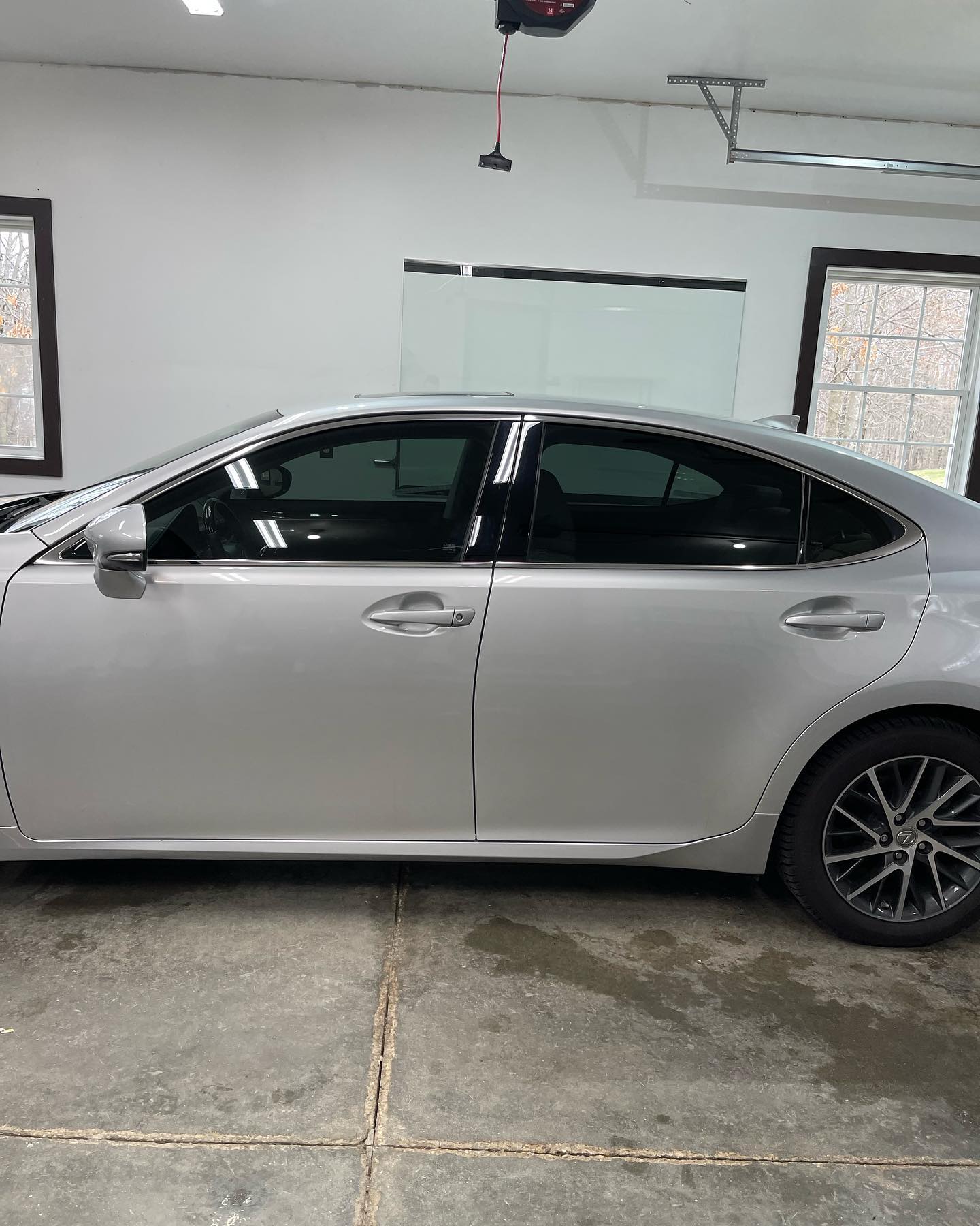 Silver sedan with tinted windows parked in a garage.