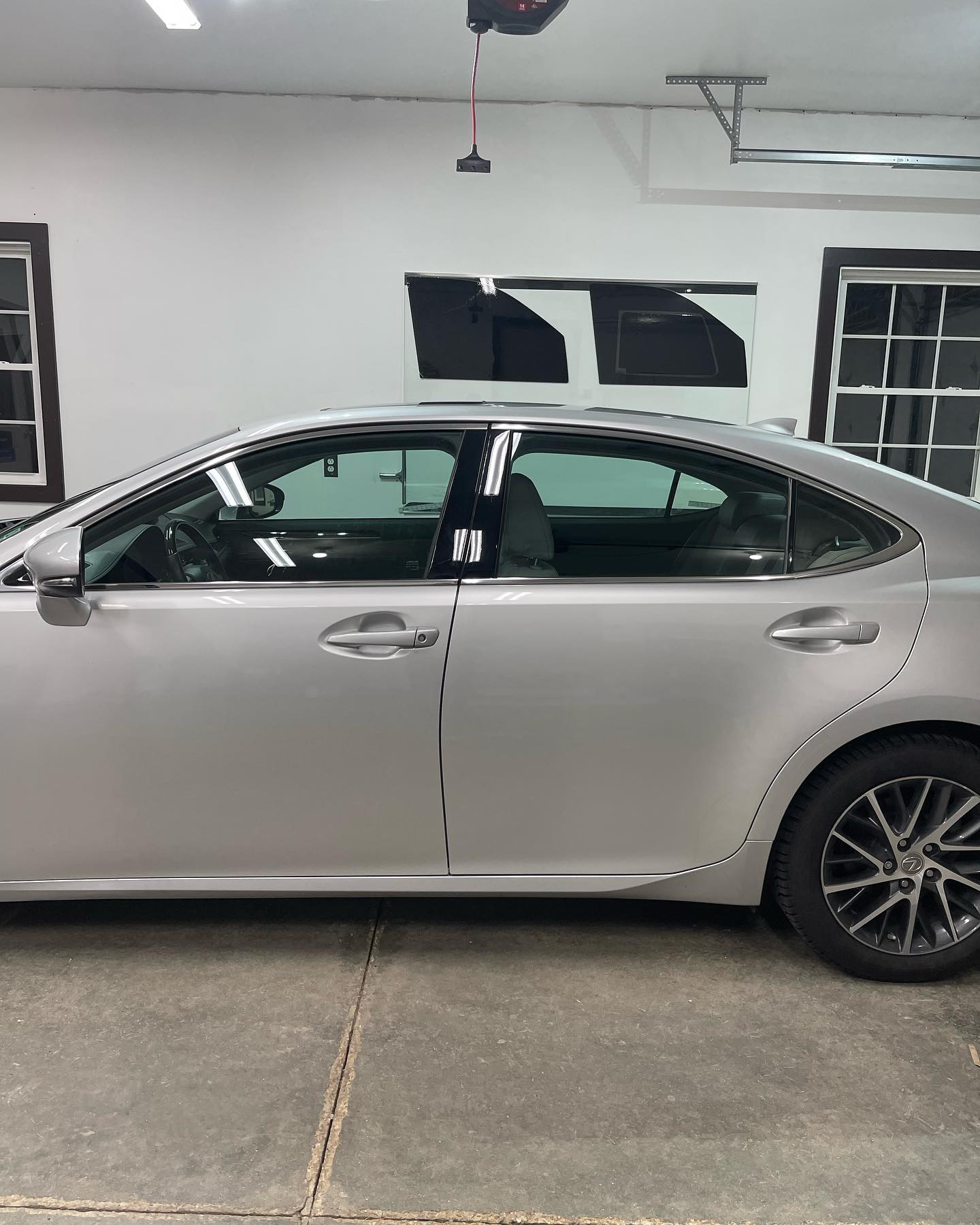 Silver Lexus sedan parked inside a garage. Dark tinted windows.