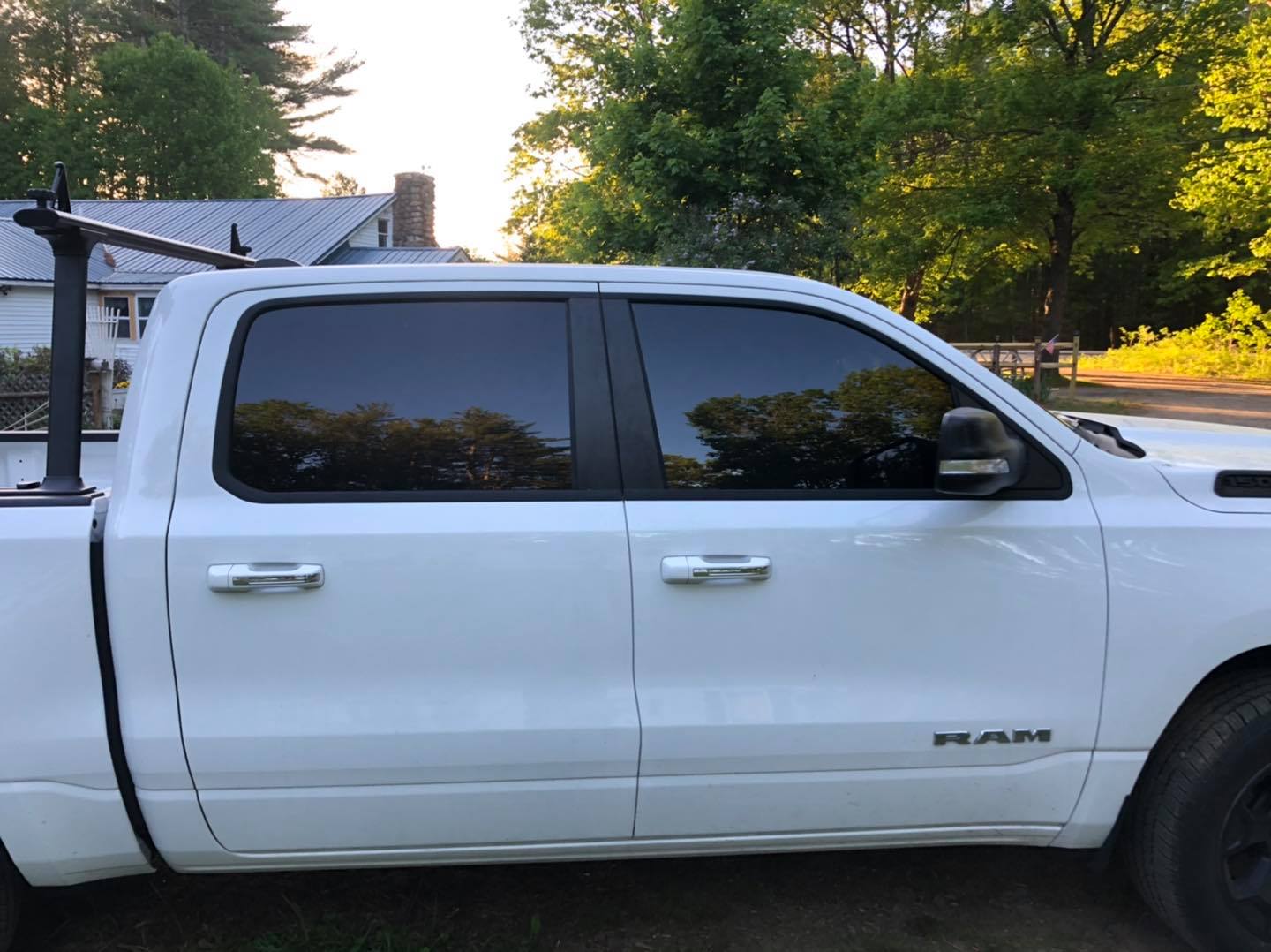 White Ram truck with tinted windows, parked outdoors.