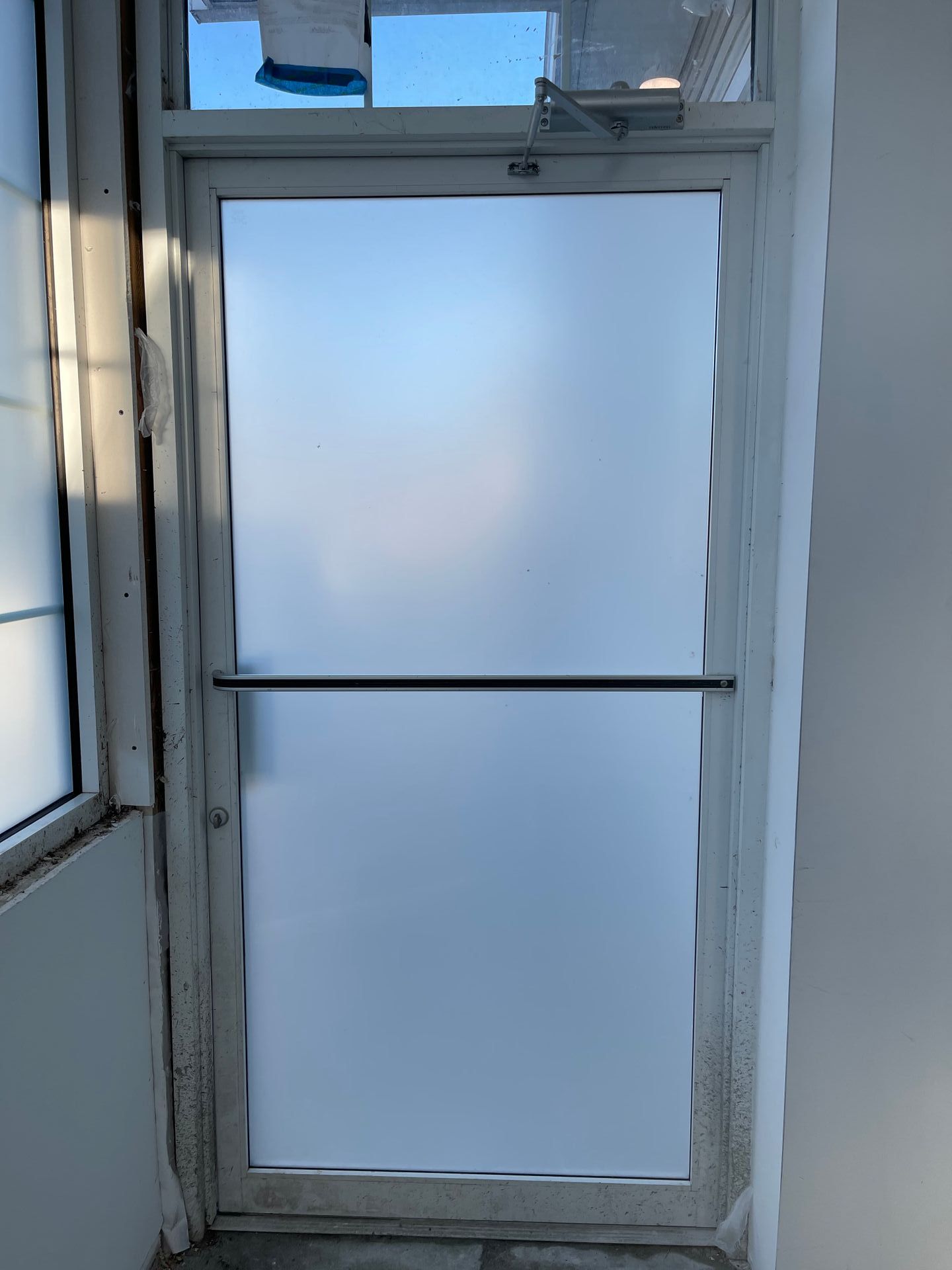 Frosted glass door with a horizontal bar, possibly an emergency exit.