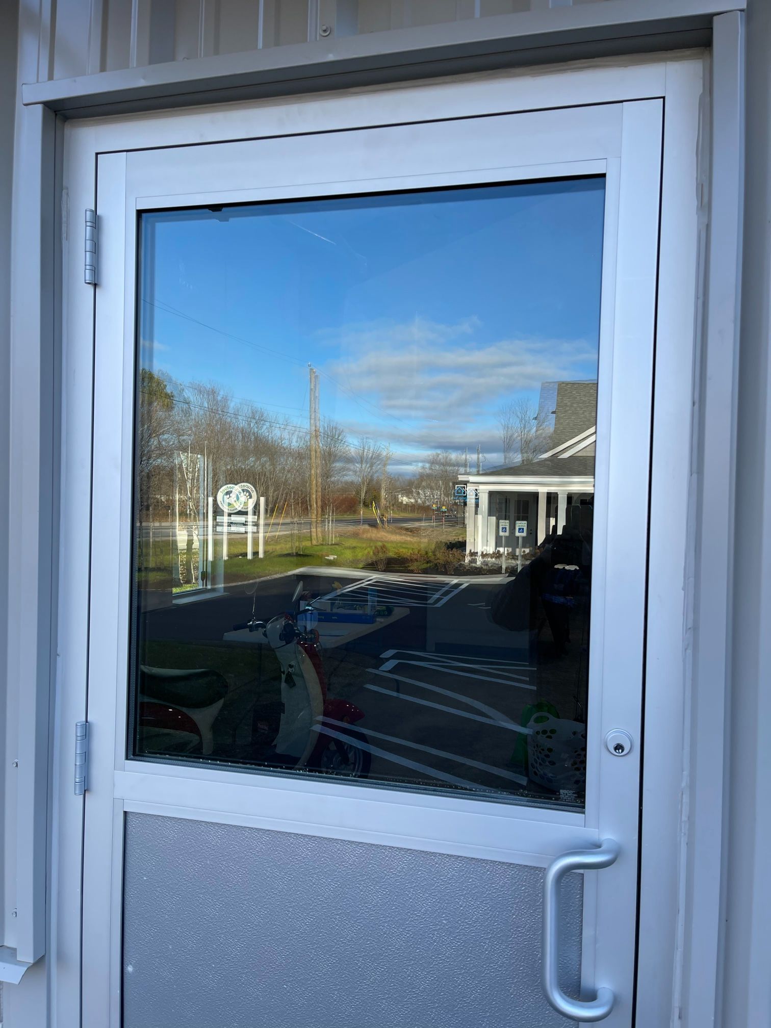 White framed door with large window, a partial textured bottom, and a silver handle.