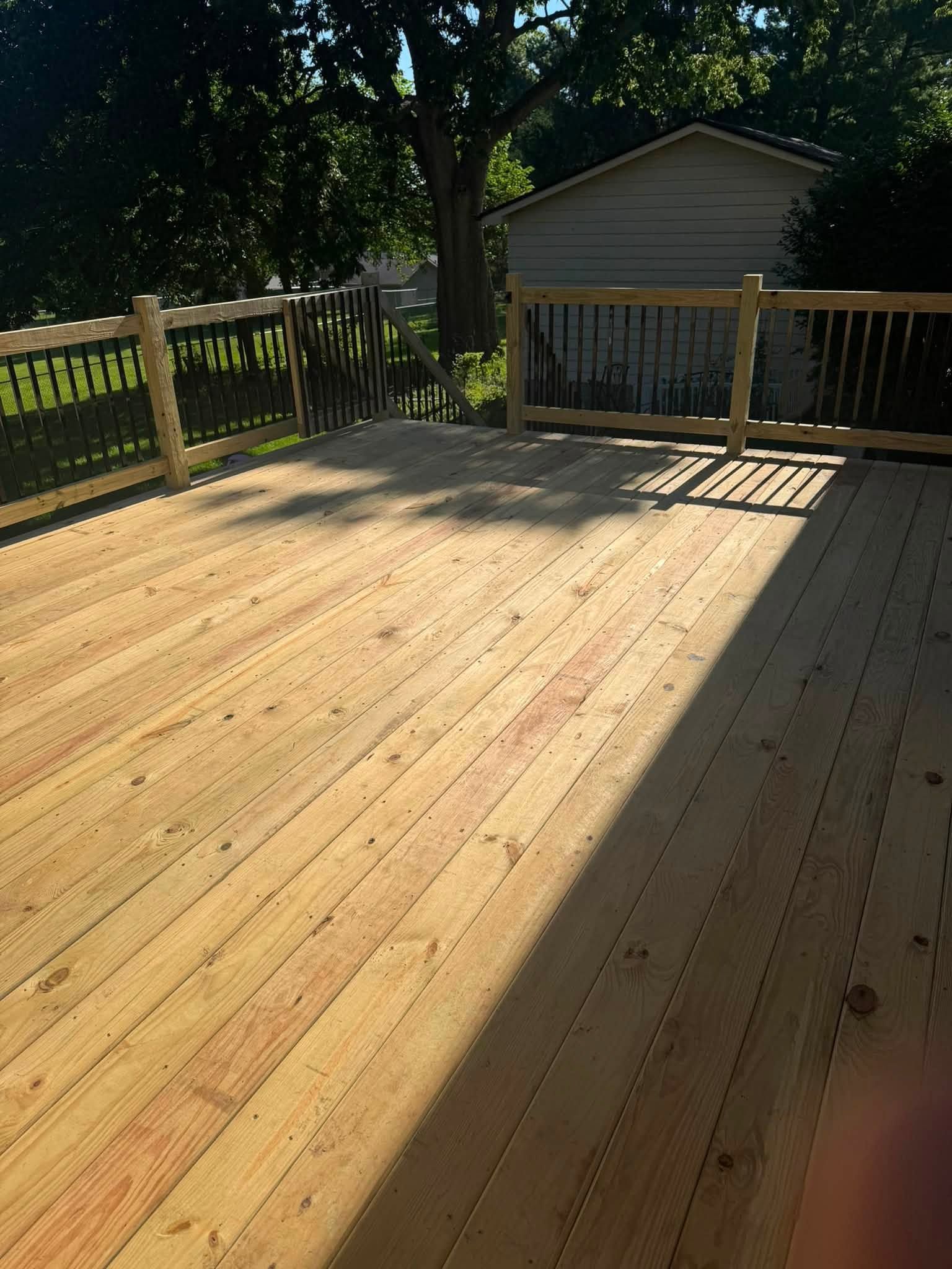 Deteriorating deck with warped boards and rusted railings on an Iowa residential home