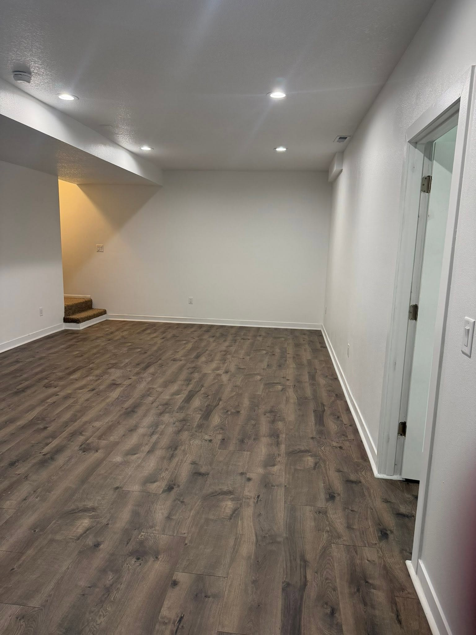 Contractor installing luxury vinyl plank flooring in an Iowa residential home