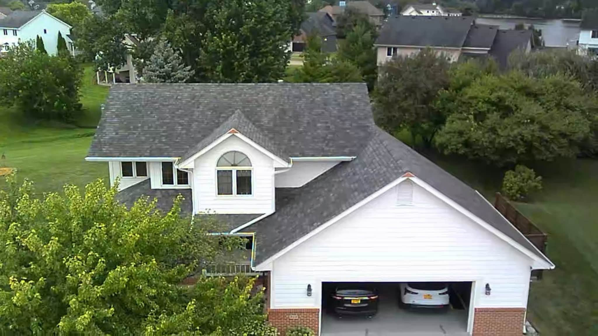 Damaged asphalt shingles on an Iowa residential roof showing curling and granule loss.