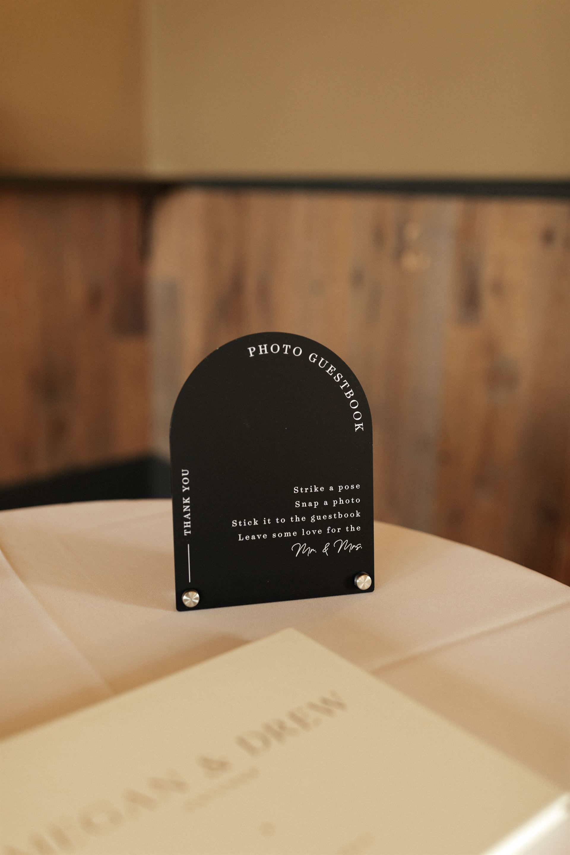 Black table sign with text on a table with a menu.