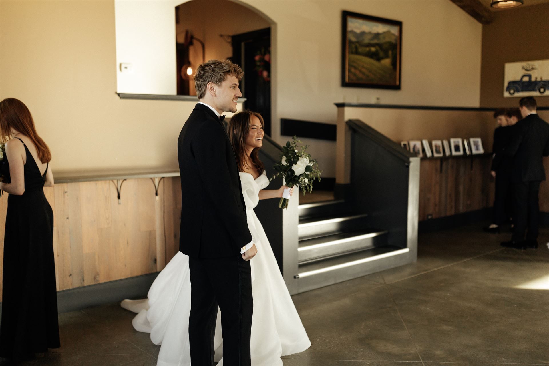 Bride and groom walking together at a wedding venue; woman in white dress, man in suit.