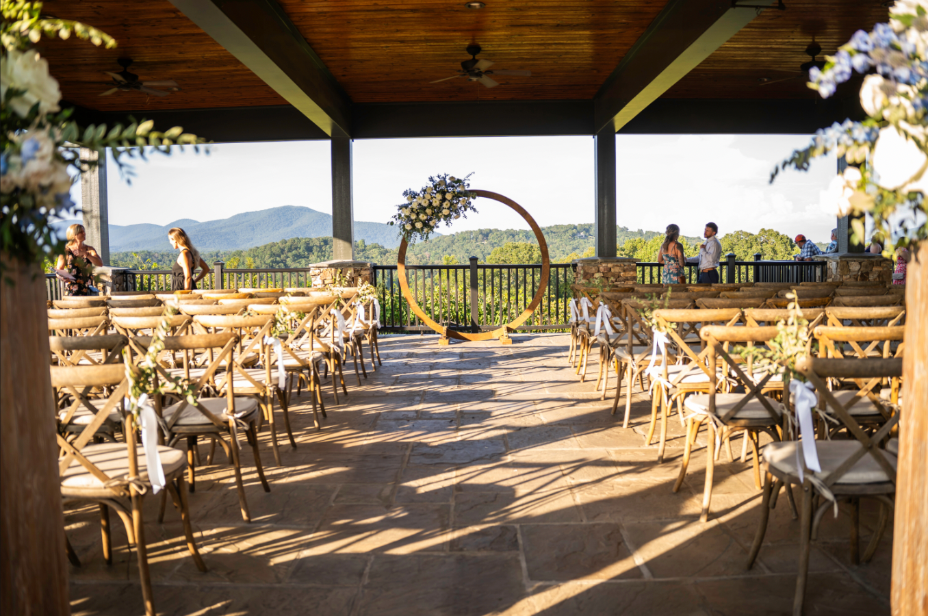 Wedding ceremony setup with chairs facing an arch and mountain view.