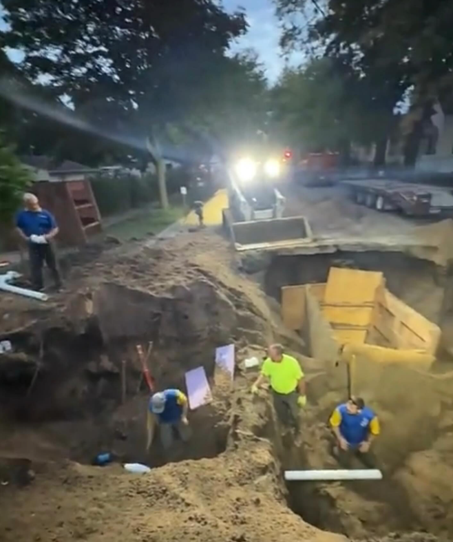 A group of construction workers are digging a hole in the ground