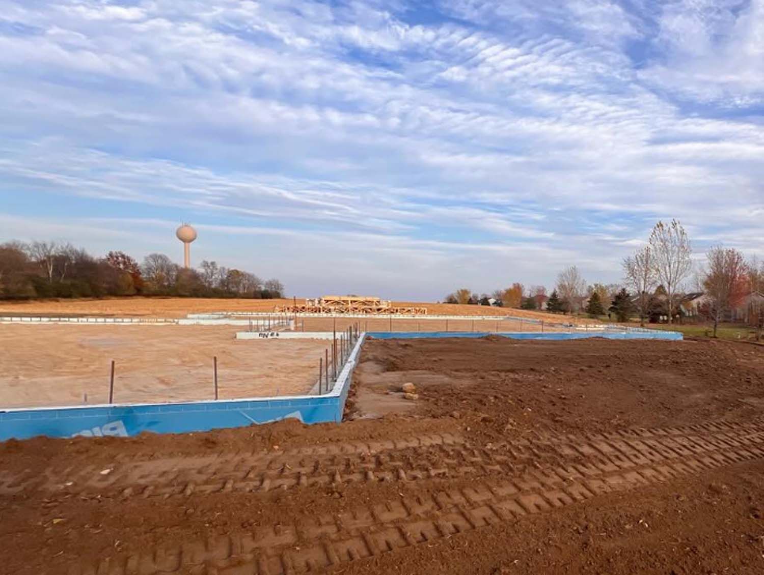 A construction site with a water tower in the background.