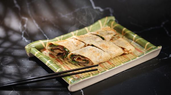 Plate of baked pastries on a green tray atop a dark countertop