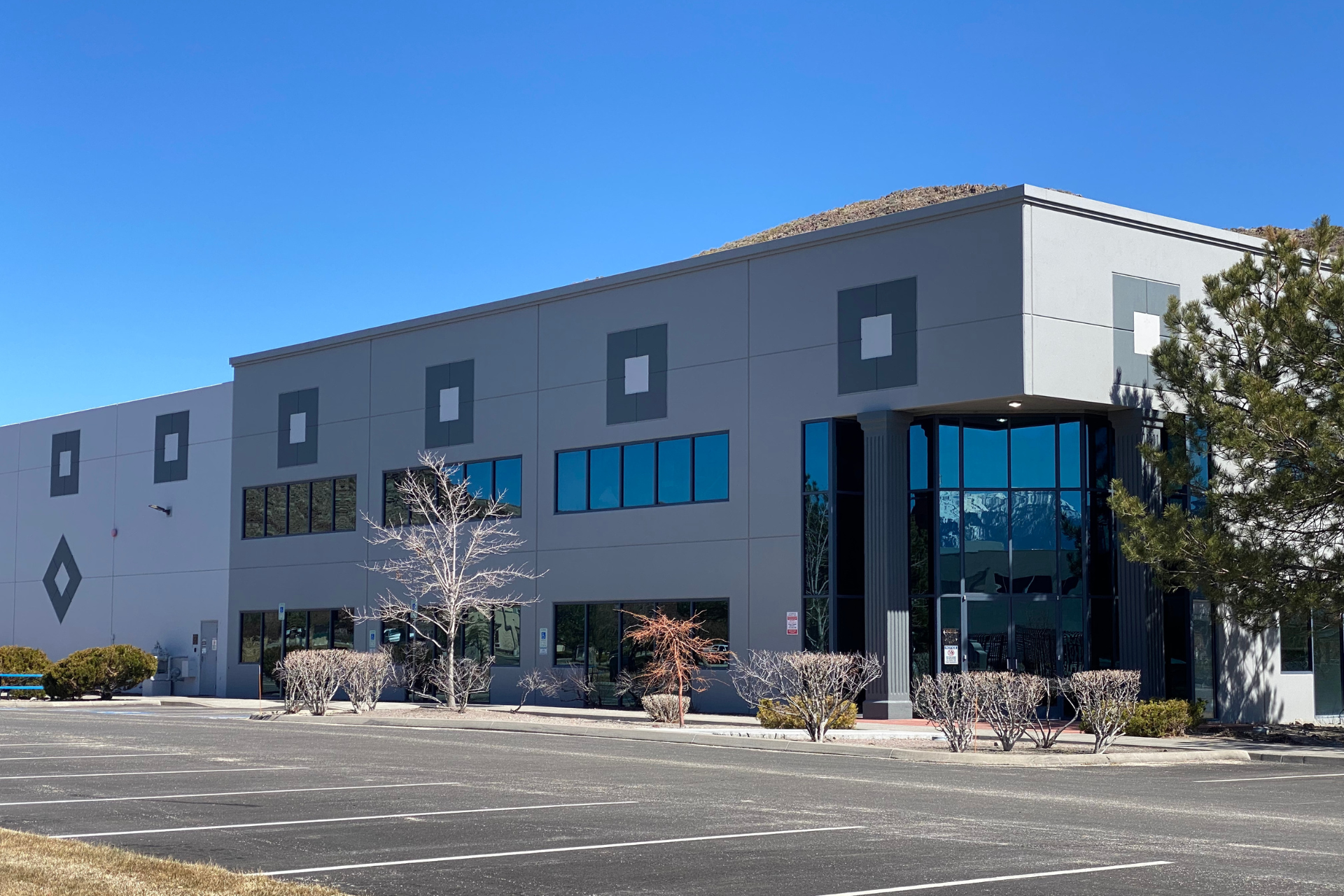 A large building with a lot of windows and trees in front of it
