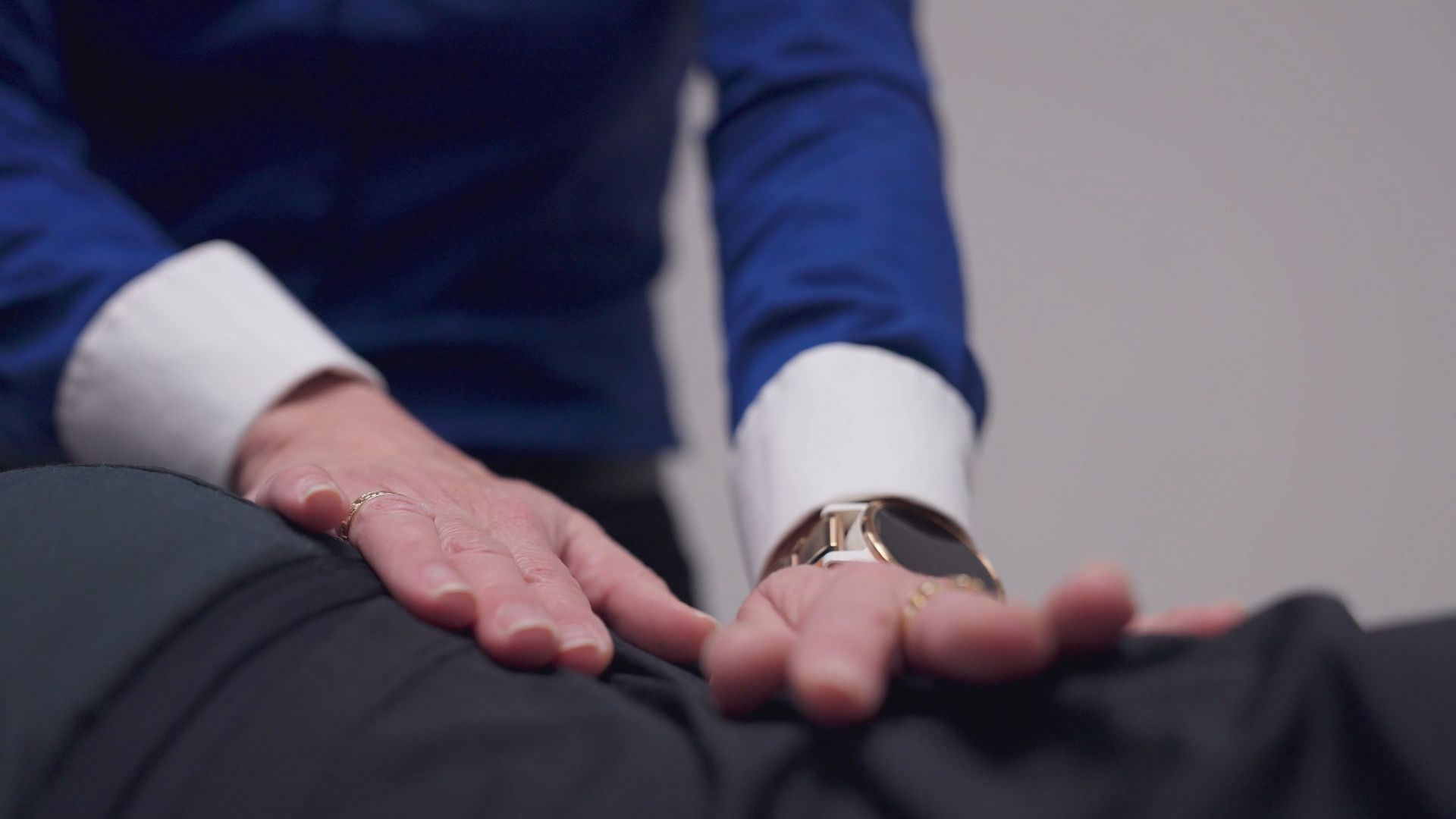 A close up of a person 's hands on another person 's back.