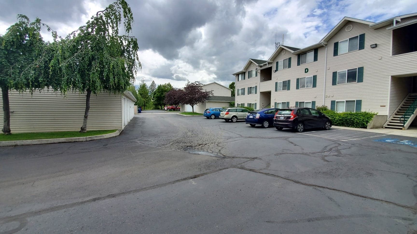 A parking lot with cars parked in front of a building.