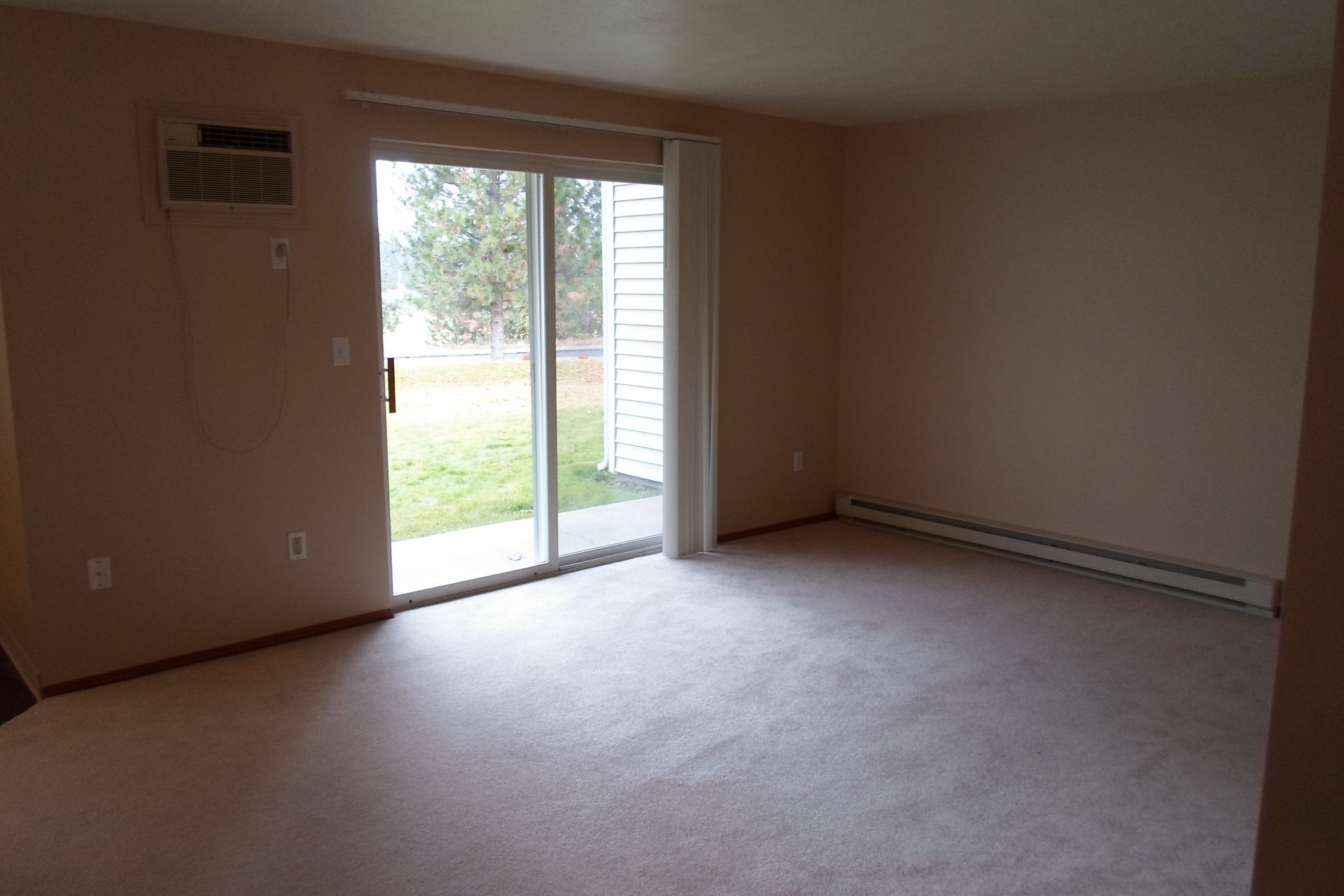 An empty living room with a sliding glass door