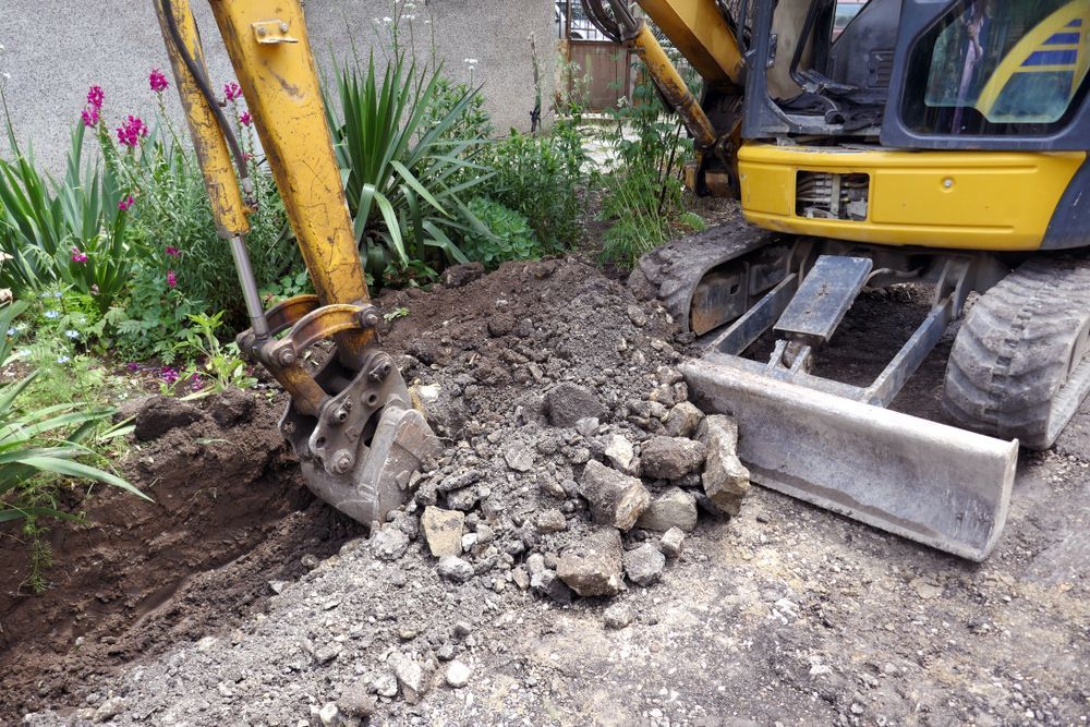 A Yellow Mini-excavator Digging a Trench in Soil — Environment Restoration Solutions in Port Macquarie, NSW