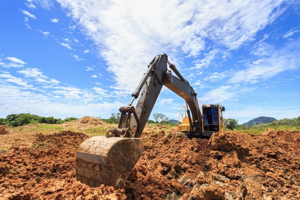 A Yellow Excavator Parked in a Dirt Lot — Environment Restoration Solutions in Waterview Heights, NSW