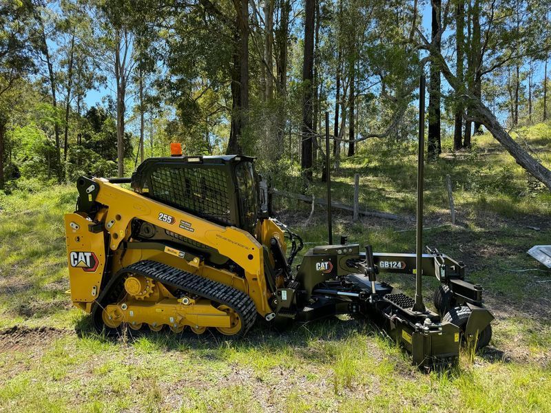 Yellow Caterpillar compact track loader with a grading blade attachment — Environment Restoration Solutions in Waterview Heights, NSW