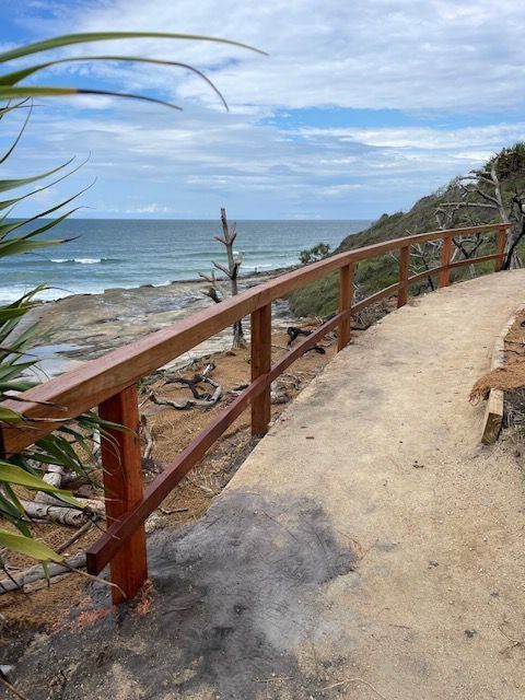 A Sandy Walking Path Curves Along a Cliffside With a Wooden Railing — Environment Restoration Solutions in Waterview Heights, NSW